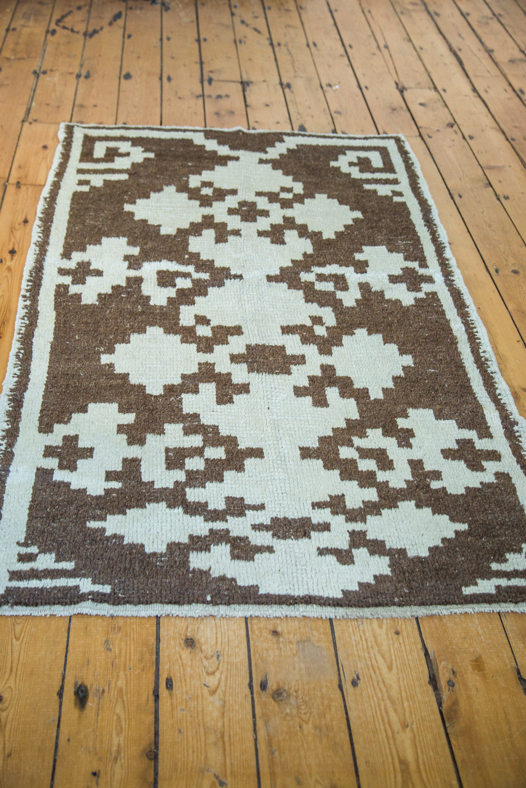 Textured vintage Tulu rug with triple geometric medallions in pale ivory and charcoal.